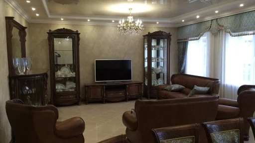 Изысканная гостиная с коричневой корпусной и мягкой мебелью